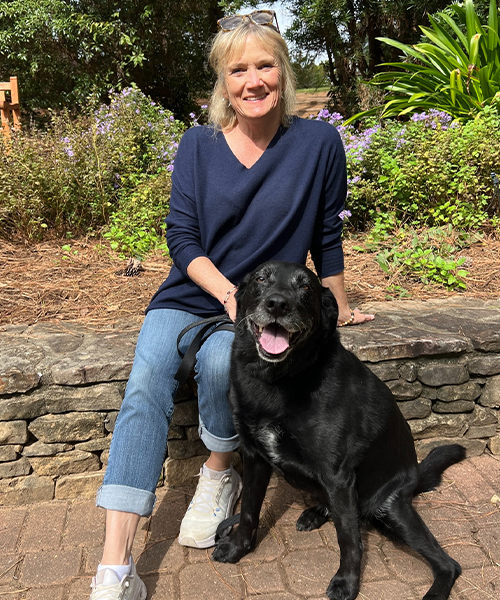 Vet sitting outside with her black dog