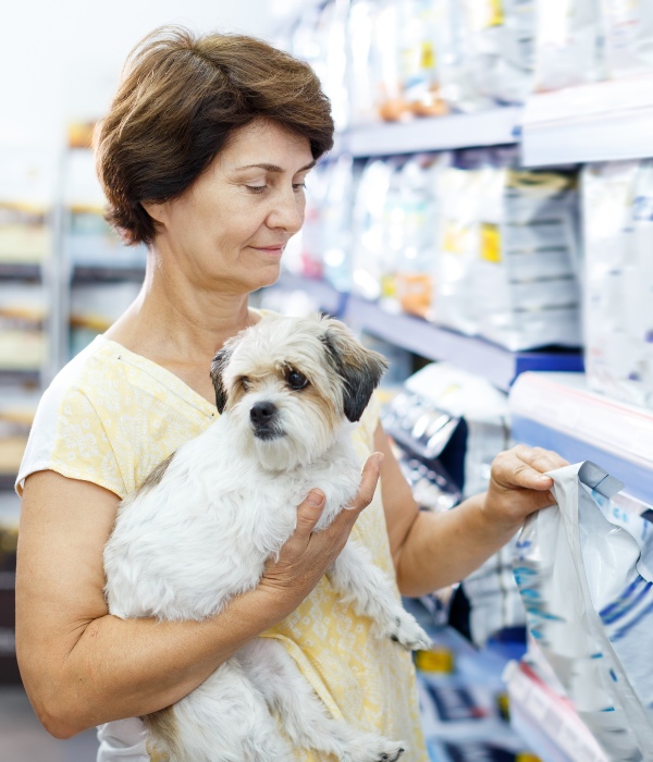 Elderly woman choosing dog food for her puppy